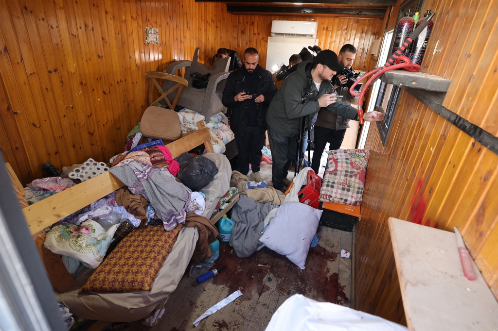 Journalists enter in the aftermath of a gunfight the scene of a raid by Israeli forces on an office where they said Palestinian militants were hiding in Jericho in the occupied West Bank on February 6, 2023
