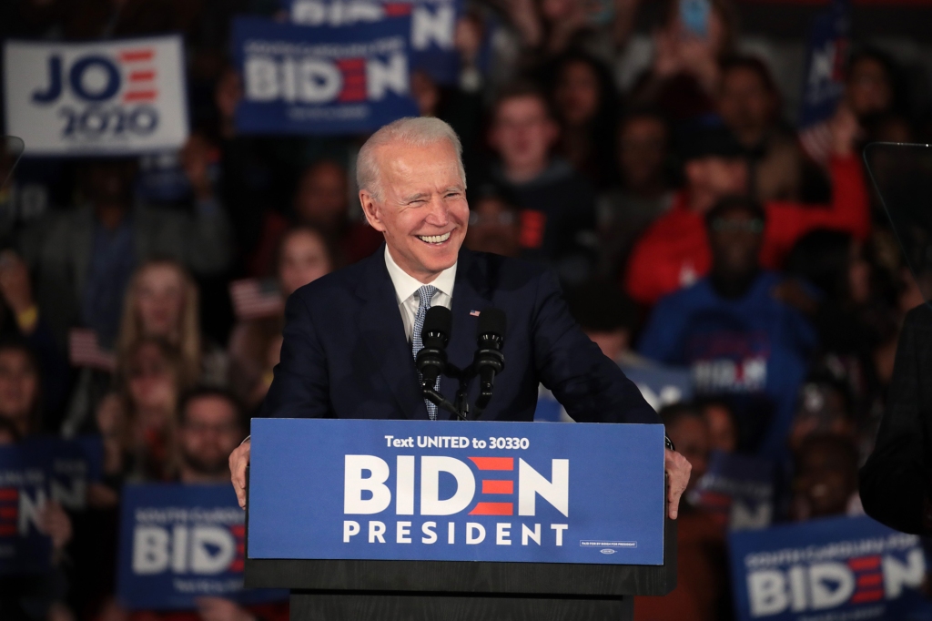 President Biden is pictured at a podium at a rally of his supporters.