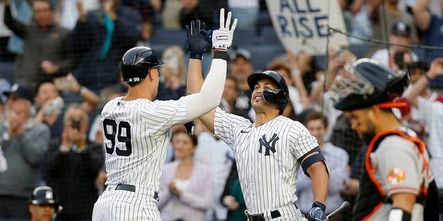 Aaron Judge (99) of the New York Yankees celebrates a home run during the first inning against the Baltimore Orioles with teammate Giancarlo Stanton at Yankee Stadium May 23, 2022, in New York City. 