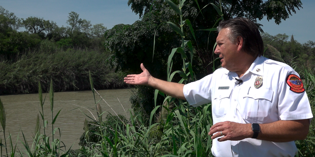 Chief Manuel Mello points to a spot in the Rio Grande where the Eagle Pass Fire Department often recovers the bodies of drowning victims. 