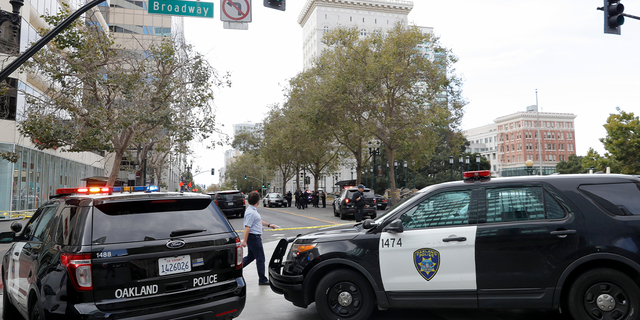 Police investigate a fatal shooting on 14th Street near Broadway in downtown Oakland, California, on Sept. 20, 2022.