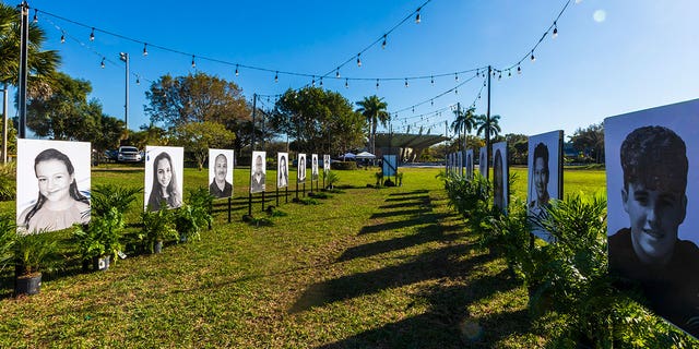 Photos of the 17 people killed during the Marjory Stoneman Douglas High School mass shooting are displayed on the fifth anniversary of the shooting on February 14, 2023, in Pine Trails Park in Parkland, Florida. On February 14, 2018, fourteen students and three staff members were killed during the shooting at the school. 