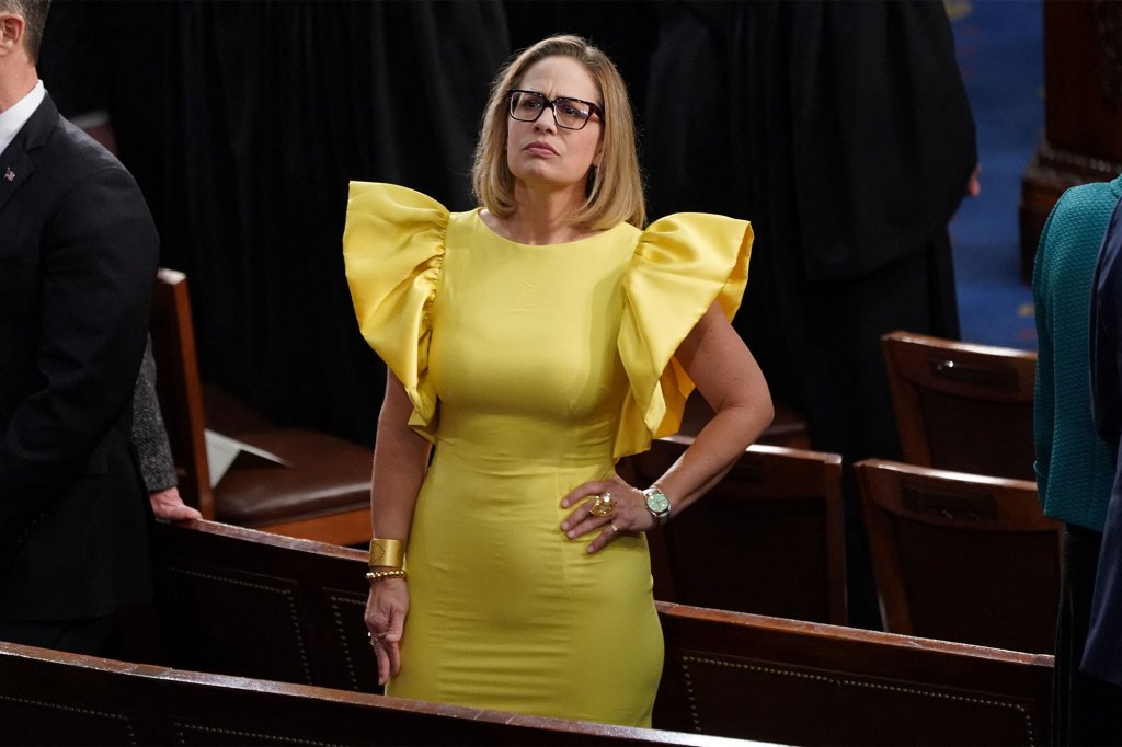 U.S. Senator Kyrsten Sinema's bright yellow dress stood out among the sea of Congress members in black and navy business attire.