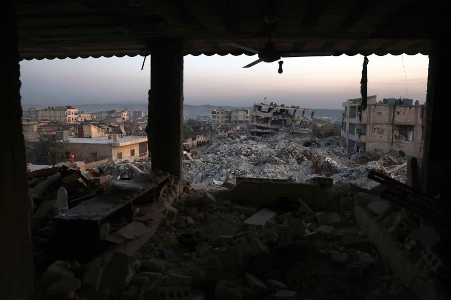 Collapsed buildings are seen through the windows of a damaged house following a devastating earthquake in the town of Jinderis, Aleppo province, Syria, Thursday, Feb. 9, 2023.