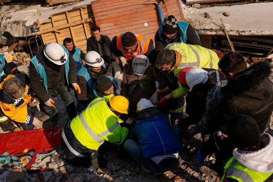 Turkish woman Hatice Korkut, center, 82, is rescued alive by rescue team members from a destroyed building in Elbistan, southeastern Turkey, Thursday, Feb. 9, 2023.