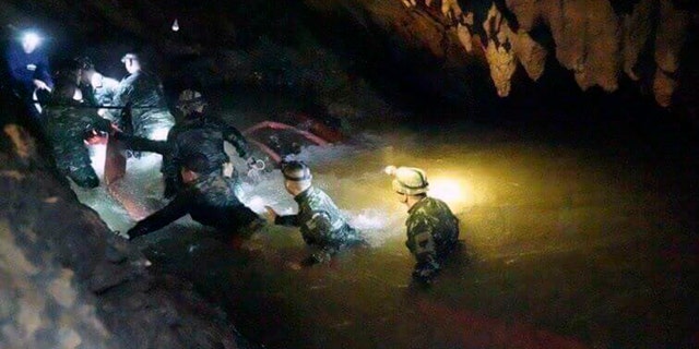 In this handout photo released by Tham Luang Rescue Operation Center, Thai rescue teams walk inside the cave complex during the operation on July 2, 2018. 