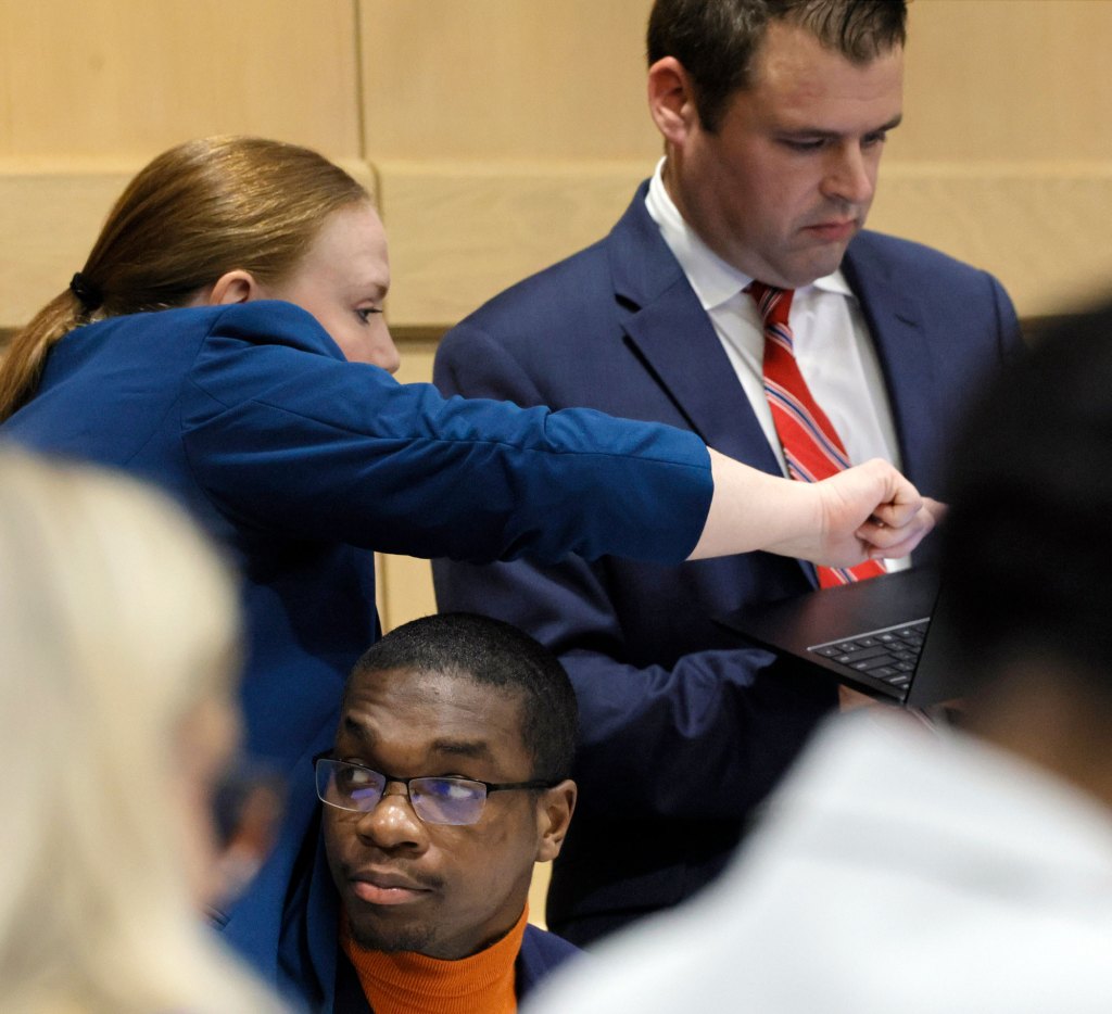 Attorneys Skyler Hill, left, and Joseph Kimok confer as shooting suspect Michael Boatwright is shown at the defense table just before opening statements.