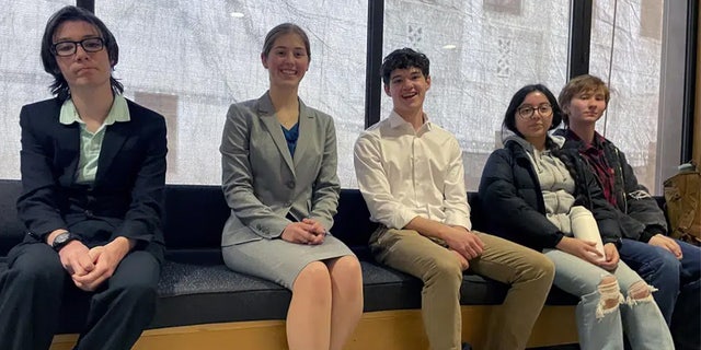 High school students sit on a bench at the Oregon State Capitol building in Salem, Ore., Thursday, March 9, 2023, before testifying at a hearing in support of a bill that would require climate change instruction in public schools from kindergarten through 12th grade.