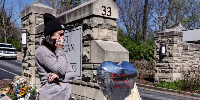 A woman wipes away tears as she visits a memorial at the entrance to The Covenant School on Wednesday, March 29, 2023, in Nashville, Tenn. 