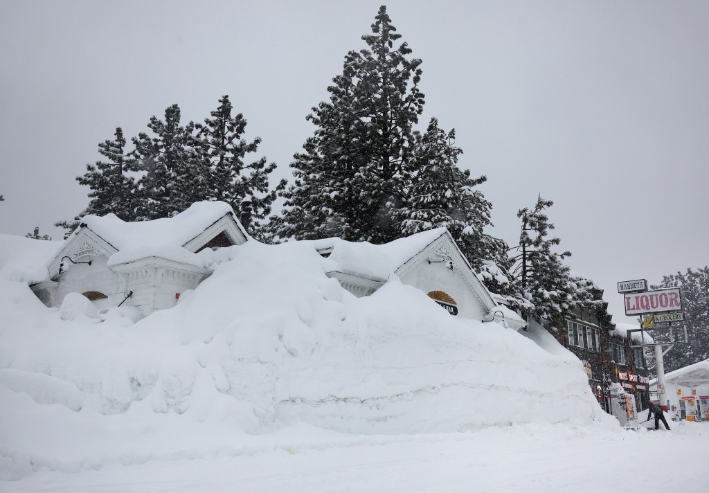 A house is piled under snowbanks in Mammoth Lakes, California on March 10, 2023.