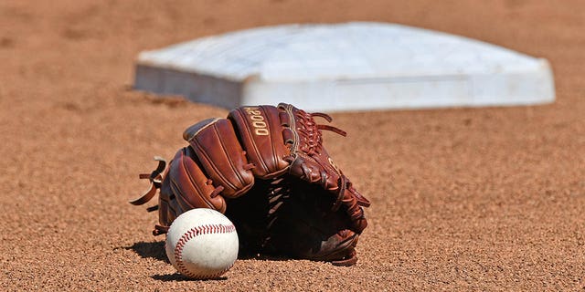 A baseball and glove in the field prior to Game 1 of the College World Series championship series between the Michigan Wolverines and Vanderbilt Commodores June 24, 2019, at TD Ameritrade Park Omaha in Omaha, Neb. 