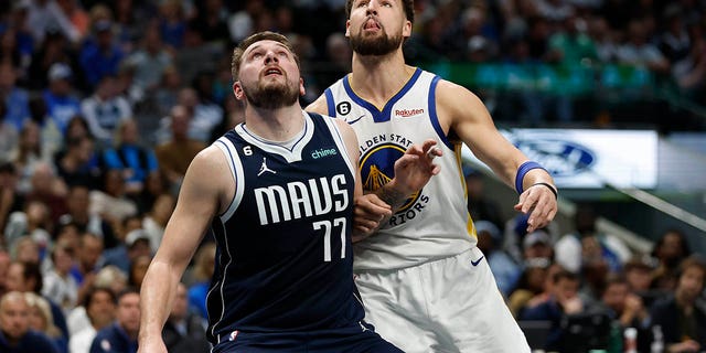 Luka Doncic #77 of the Dallas Mavericks and Klay Thompson #11 of the Golden State Warriors battle for position in the first half at American Airlines Center on March 22, 2023 in Dallas, Texas.