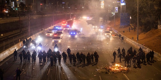 Israeli police disperse demonstrators blocking a highway during a protest against plans by Prime Minister Benjamin Netanyahu's government to overhaul the judicial system in Tel Aviv, Israel, Monday, March 27, 2023. 