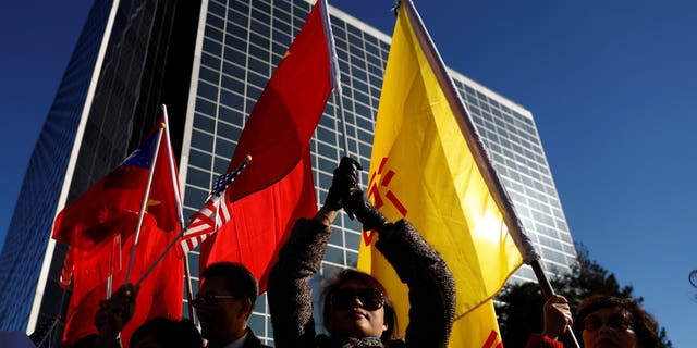 Demonstrators holds flags of China and Taiwan during Taiwanese President Tsai Ing-wen's stop-over after her visit to Latin America January 2017.