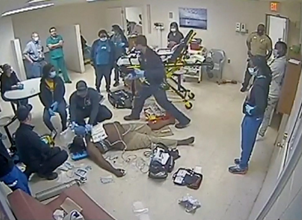 Medical staff aid Irvo Otieno, as the 28-year-old is positioned on his back in one of the hospital rooms. 