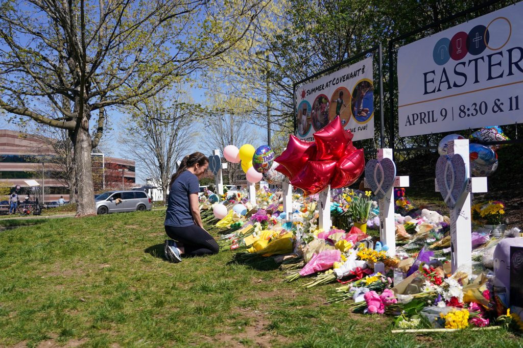 A mourner leaves flowers at a makeshift memorial for the victims of Monday's school shooting in Nashville.