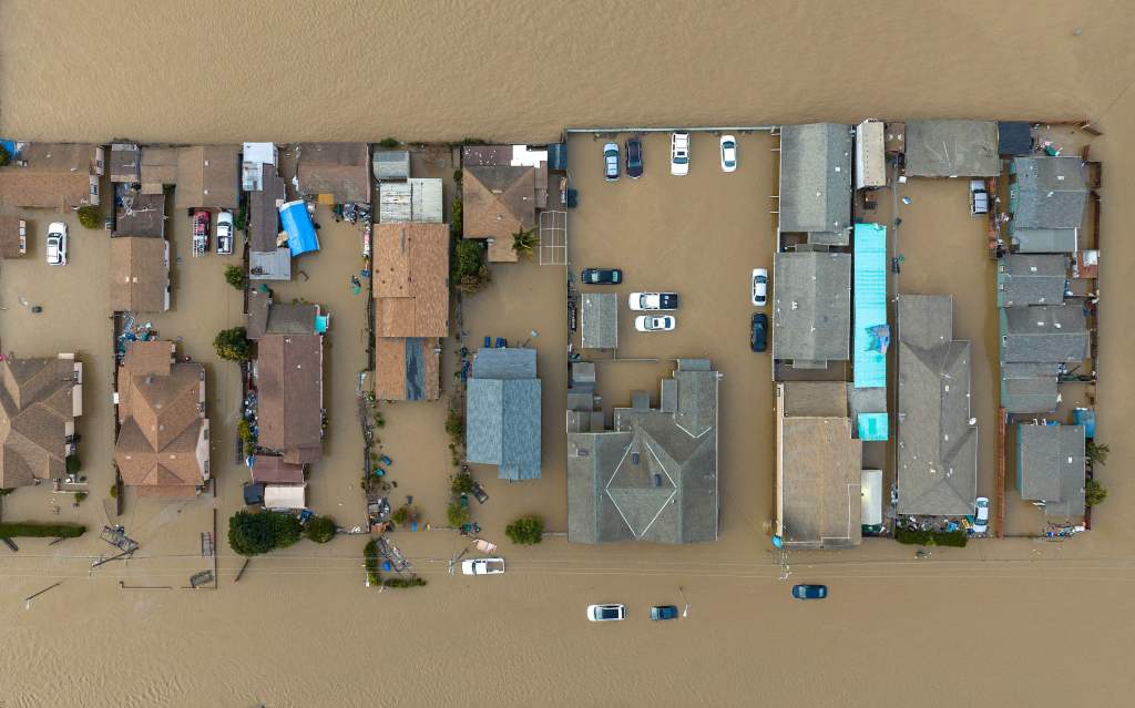 Floodwaters surround a car and market shop in Pajaro, California on March 12, 2023. 