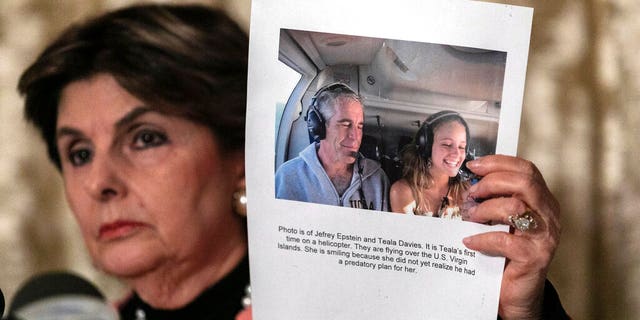 Attorney Gloria Allred, holds a picture of Jeffrey Epstein and her client Teala Davis during a news conference, Thursday, Nov. 21, 2019, in New York, about the filing of a lawsuit against the estate of Epstein. Davies says she was 17 when she was victimized by Epstein. 