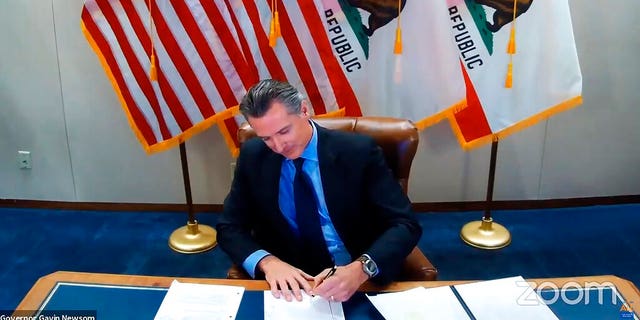 This image made from video from the Office of the Governor shows California Gov. Gavin Newsom signing into law a bill that establishes a task force to come up with recommendations on how to give reparations to Black Americans on Sept. 30, 2020, in Sacramento, Calif.