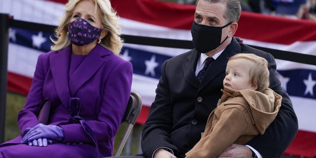 Jill Biden, left, sits with Hunter Biden and his child during an event at the Major Joseph R. "Beau" Biden III National Guard/Reserve Center, on Jan. 19, 2021, in New Castle, Delaware.