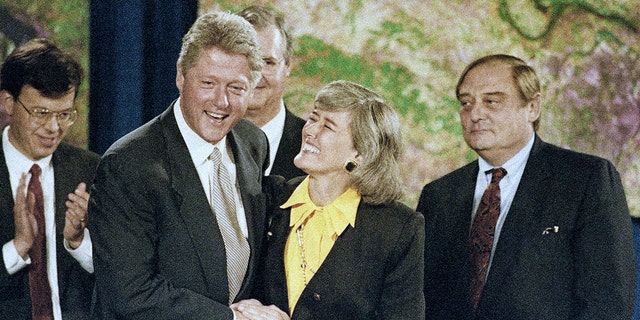 FILE - President Bill Clinton introduces Rep. Pat Schroeder, of Colorado, during a ceremony honoring community heroes from flood-afflicted states in St. Louis, on Aug. 12, 1993. 