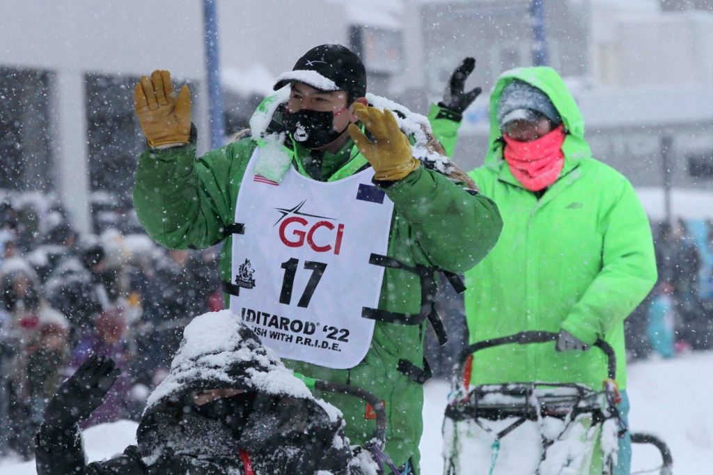 Ryan Redington greets fans while taking his sled dogs through a snowstorm in downtown Anchorage, Alaska on the first day. 