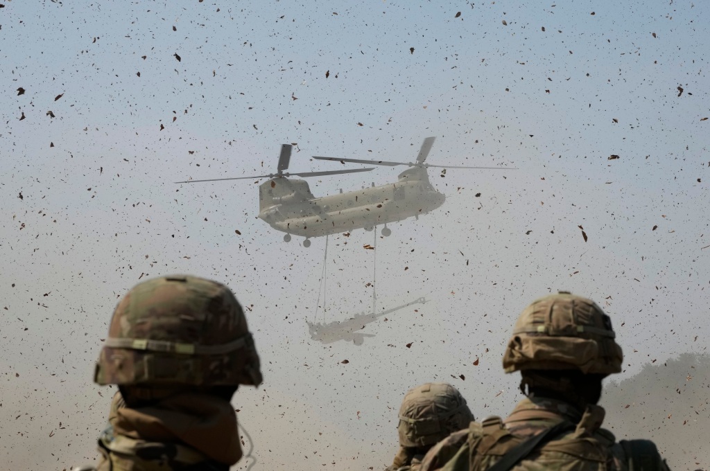 A U.S Army CH-47 Chinook helicopter transports a M777 howitzer during a joint military drill between South Korea and the United States at Rodriguez Live Fire Complex in Pocheon, South Korea on March 19, 2023. 