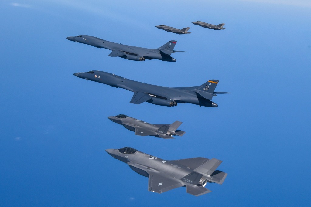 U.S. Air Force B-1B bombers (center) fly in formation with South Korea's Air Force F-35A fighter jets over the South Korea Peninsula during a joint air drill in South Korea on March 19, 2023. 