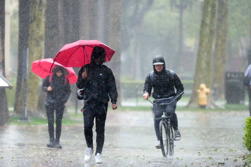 Rain falls on pedestrians at the University of Southern California campus on March 21, 2023, in Los Angeles. 