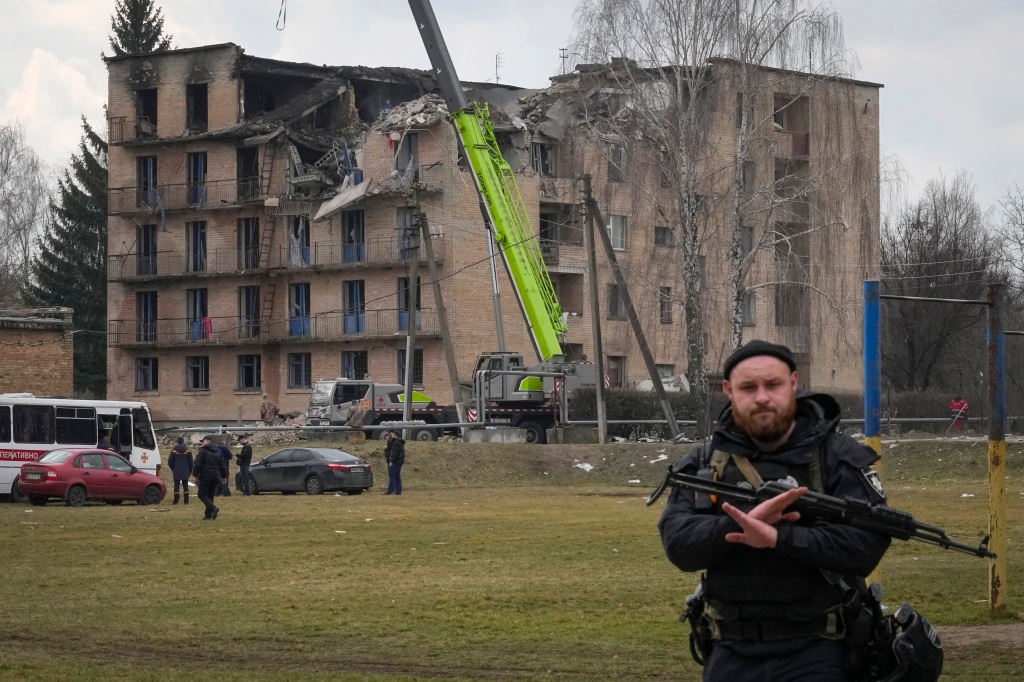 A police officer gestures to prevent photographing at the scene of a drone attack in the town of Rzhyshchiv, Kyiv region, Ukraine on March 22, 2023.