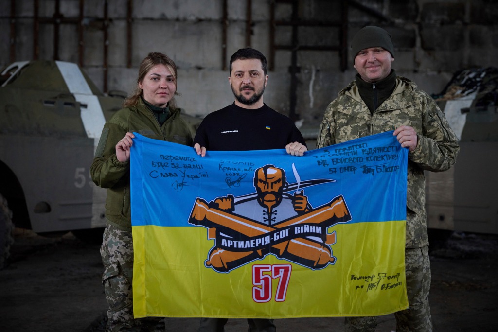 Ukrainian president Volodymyr Zelenskyy and Ukrainian soldiers hold the flag of a military unit at a position near Bakhmut, Donetsk region, Ukraine on March 22, 2023.