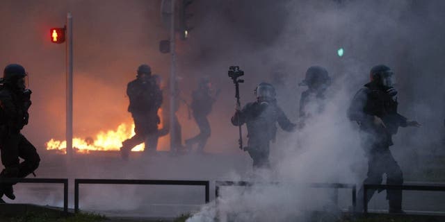 Riot police scuffle with protesters on the sideline of a rally in Strasbourg, France, Thursday, March 23, 2023.