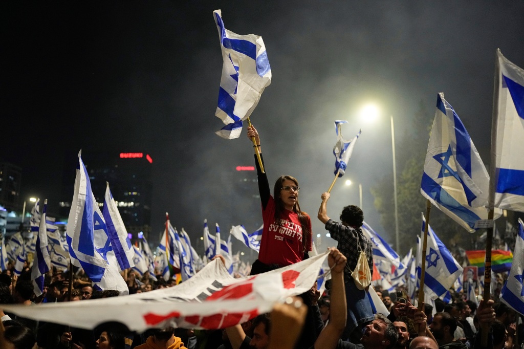 Protesters wave flags during the protest after the Israeli leader fired his defense minister in Tel Aviv, Israel on March 26, 2023. 