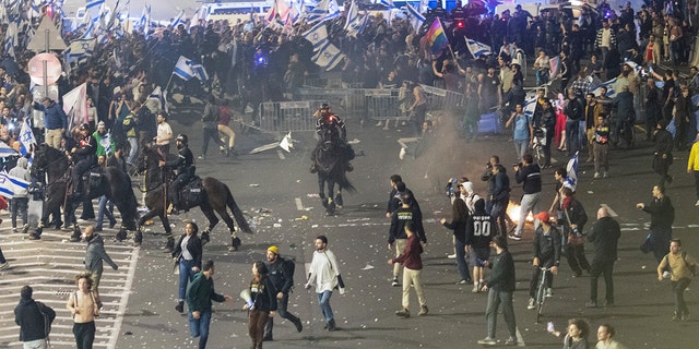 Israeli police disperse demonstrators blocking a highway during a protest against plans by Prime Minister Benjamin Netanyahu's government to overhaul the judicial system in Tel Aviv, Israel, Monday, March 27, 2023. 