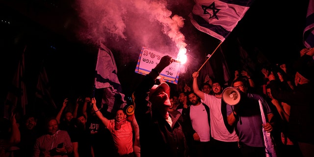 Israelis opposed to Prime Minister Benjamin Netanyahu's judicial overhaul plan block a highway during a protest after the Israeli leader fired his defense minister, in Tel Aviv, Israel, Monday, March 27, 2023. 