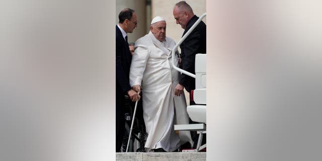 Pope Francis helped to get on his car at the end of weekly general audience in St. Peter's Square, at the Vatican, Wednesday, March 29, 2023. 