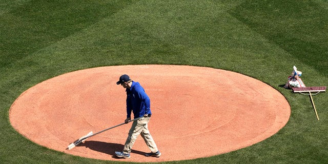 A member of the Kansas City Royals' grounds crew works the field in preparation for the 2023 baseball season Wednesday, March 29, 2023, at Kauffman stadium in Kansas City, Missouri. The Royals will host the Minnesota Twins on MLB's opening day tomorrow.