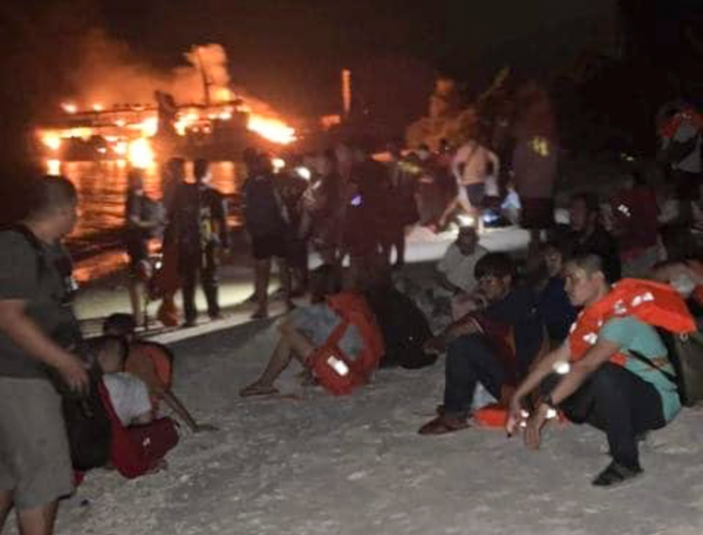 Survivors rest after being rescued from the still burning MV Lady Mary Joy at Basilan, in southern Philippines on March 30, 2023.