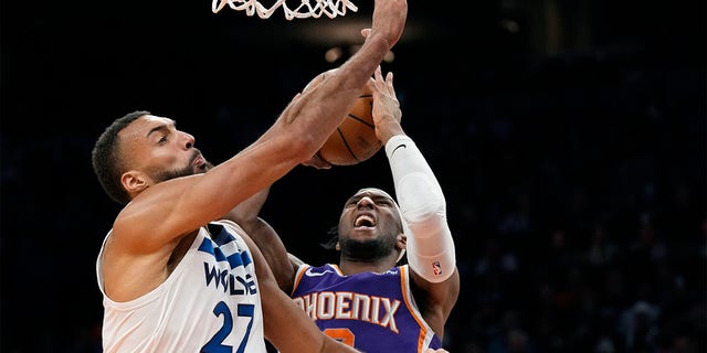 Suns forward Josh Okogie gets fouled as he goes up for a shot against Minnesota Timberwolves center Rudy Gobert, Wednesday, March 29, 2023, in Phoenix. The Suns won 107-100.