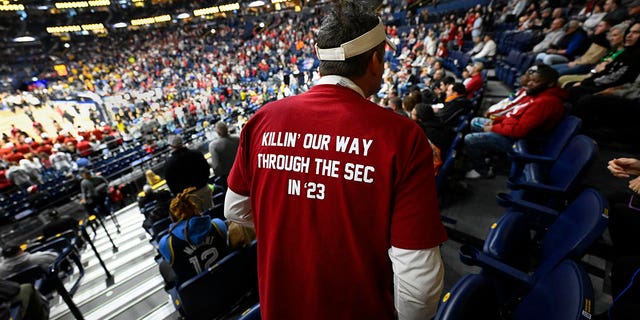 An Alabama fan, who had on a custom-made T-shirt, takes his seat before an NCAA college basketball game against Missouri in the semifinals of the Southeastern Conference Tournament, Saturday, March 11, 2023, in Nashville, Tennessee.