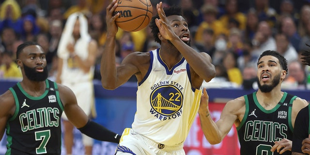 Golden State Warriors forward Andrew Wiggins (22) shoots against Boston Celtics guard Jaylen Brown (7) and forward Jayson Tatum (0) during the first half of Game 5 of the NBA Finals in San Francisco June 13, 2022. 