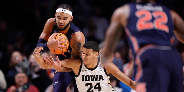 Johni Broome #4 of the Auburn Tigers and Kris Murray #24 of the Iowa Hawkeyes battle for the ball during the second half in the first round of the NCAA Men's Basketball Tournament at Legacy Arena at the BJCC on March 16, 2023 in Birmingham, Alabama.