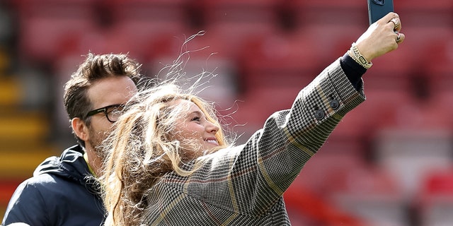 Wrexham co-owner Ryan Reynolds has his picture taken by wife Blake Lively prior to a Vanarama National League match between Wrexham and York City at the Racecourse Ground March 25, 2023, in Wrexham, Wales.