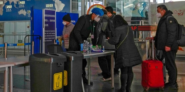 Passengers wearing face masks line up for security check before entering an international departure gate at the Beijing Capital International Airport in Beijing, Thursday, Dec. 29, 2022. Moves by the U.S., Japan and others to mandate COVID-19 tests for passengers arriving from China reflect global concern that new variants could emerge in its ongoing explosive outbreak — and the government may not inform the rest of the world quickly enough. 