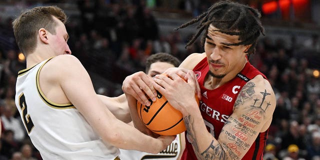 Caleb McConnell, #22 of the Rutgers Scarlet Knights, and Fletcher Loyer, #2 of the Purdue Boilermakers, battle for the basketball during the second half in the quarterfinals of the Big Ten Tournament at United Center on March 10, 2023 in Chicago.