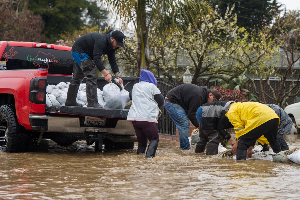 Residents lay sandbags on a flooded road in Watsonville, Calif. on Friday.
