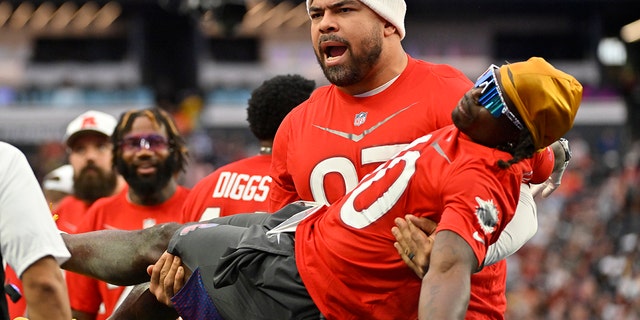 AFC defensive tackle Cameron Heyward of the Pittsburgh Steelers carries AFC wide receiver Tyreek Hill of the Miami Dolphins during the flag football event at the NFL Pro Bowl against the NFC, Sunday, Feb. 5, 2023, in Las Vegas.