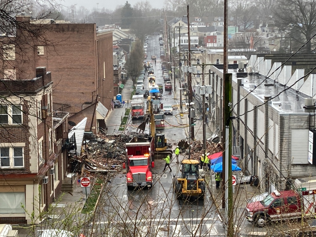 Emergency responders and heavy equipment are seen at the site of a deadly explosion at a chocolate factory.