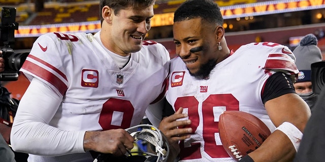 New York Giants quarterback Daniel Jones (8) and running back Saquon Barkley (26) walk off the field after a 20-12 victory over the Washington Commanders Dec. 18, 2022, in Landover, Md. 