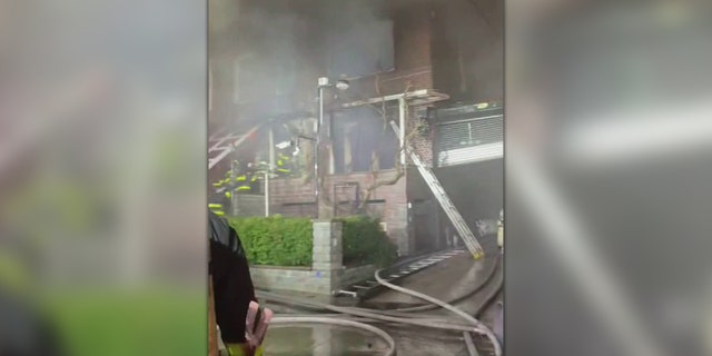 FDNY firefighters are seen heading into a smoking building in the Woodside neighborhood.